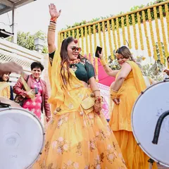 The bride dances with abandon to the beat of the dhol. I focus on capturing the high-energy moments and the vibrant colors of the Haldi ceremony.