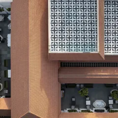 An aerial perspective of the Elgin Cafe, revealing the geometric precision of the layout. The design interlocks the terracotta-tiled roof with a patterned glass skylight and open-air courtyards.