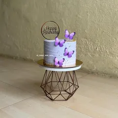 A lovely lavender birthday cake adorned with purple butterflies and a "Happy Birthday" topper. This shows a simple yet beautiful application of the theme.