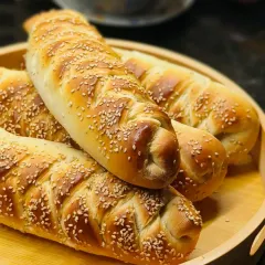 A close-up of my golden, sesame-studded Chicken Stuffed Bread, fresh from the oven. The braided top isn't just for looks; it holds in all the delicious, creamy chicken filling that my customers love.