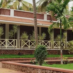 We designed this 8000 sqft farmhouse, "Grid in the Grove," to coexist with nature. The structure embraces the existing coconut grove, using rustic materials like terracotta and unfinished granite to create a timeless retreat inspired by Hampi's architectural splendor.