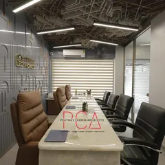 A view of the main conference room at StyleIn Homes, highlighting the interplay of the complex acoustic ceiling, custom CNC-milled wall panels, and luxurious leather seating. The design balances corporate professionalism with bold architectural statements.