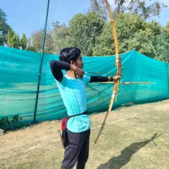An archer takes aim at our training facility, demonstrating the focus and proper form taught by our expert coaches.