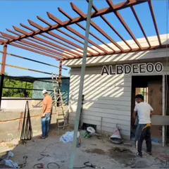 This work-in-progress shot from a site in Rohini shows a large pergola frame being installed next to a prefabricated room. You can see the basic structure before the final roofing and finishing touches are applied.