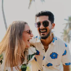 The kind of laughter that's infectious. This close-up from a Goa pre-wedding shoot captures a moment of pure, uninhibited joy between the couple, with a beautiful, sunny backdrop.
