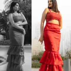 A modern red ensemble designed for a photoshoot. This outfit features a tiered mermaid-style skirt and a matching embellished crop top, creating a bold and fashionable statement.