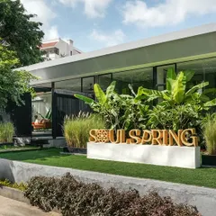 The exterior of the Soul Spring center, where landscape design takes center stage. We used layered greenery, including manicured lawns, shrubs, and mature trees, to embed the building within a natural, park-like setting.