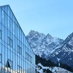 The Hamsa Resort in Manali features a modern glass and steel facade that reflects the surrounding Himalayan peaks. This design choice creates a direct visual dialogue between the structure and its environment, while the building itself incorporates traditional Kathkuni construction principles.