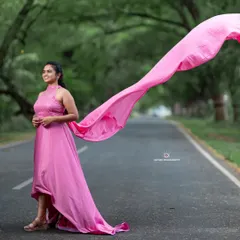A full view of the pink trail gown, showcasing its length and how it creates a beautiful line in an outdoor setting.