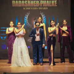 Taking a bow on stage at the Dadasaheb Phalke Achievers Award show with models showcasing my collection. The lineup includes a variety of evening gowns and two-piece sets.