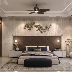 This bedroom achieves a warm, earthy feel with a textured concrete-finish wall and a diamond-patterned upholstered headboard. The hanging pendant lights and abstract metal wall art add layers of detail and personality.