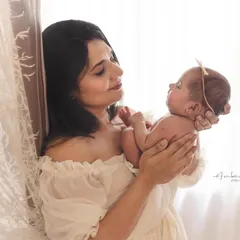 A mother's loving gaze at her newborn baby, captured in soft, natural light. These are the quiet, fleeting moments of early motherhood that I aim to make eternal.