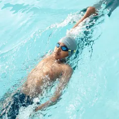 Every stroke is a step closer to greatness. An advanced swimmer practices their backstroke, focusing on reach and rotation.