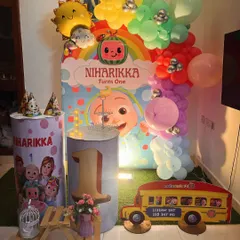 A vibrant Cocomelon theme for a first birthday, featuring a colorful backdrop, character props, and a custom-printed pedestal with the number '1'.