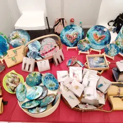 A close up of my stall, showcasing a variety of my creations. This includes decorative resin plates, coasters, unique jewelry, and hand-stitched pouches, all featuring my signature ocean and earth inspired aesthetic.