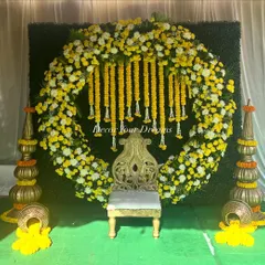 A perfect example of our vibrant Haldi ceremony decor. We created a full circular arch with yellow marigolds and white chrysanthemums, complete with a traditional seat and decorative pots, making for a stunning photo opportunity.