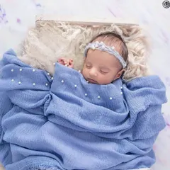 The purest serenity. I specialize in creating a safe and peaceful environment to capture your newborn in their most natural state. This little one, swaddled in soft blue and adorned with delicate pearls, is a perfect example of the timeless, artful portraits I create.