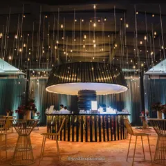 The bar is often the heart of a cocktail night. For this sangeet, we designed a statement circular bar with dramatic overhead lighting and a black and gold aesthetic to create a chic, nightclub-inspired focal point.