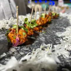 A row of perfectly spiced and grilled paneer skewers. This appetizer is a delicious and satisfying option, showcasing our ability to create flavorful vegetarian bites that are a hit with all guests.
