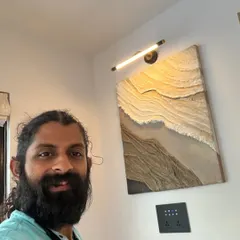 Here I am with a finished textured wall art piece. The custom lighting above it highlights the 3D waves and patterns, making it a dynamic focal point.