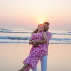 A playful and romantic pre-wedding moment as the sun sets over the ocean. Beach photoshoots like this are a wonderful way to capture your love in a relaxed, natural setting before the big day.