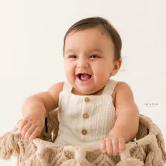 A bucket of joy! This happy baby is all smiles while sitting in a woven macrame basket, a fun and popular prop for sitter sessions.
