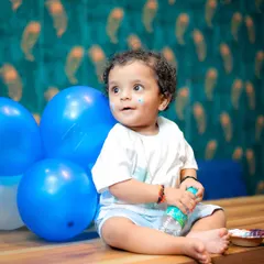 A little bit of cake on the face adds to the story. This photo captures the aftermath of a little treat during his first birthday session.