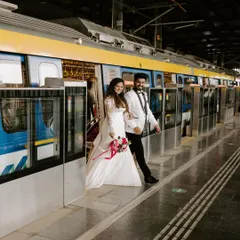 A stylish exit from the metro. This shot captures the couple stepping out of the train in their wedding attire, creating a striking contrast between formal wear and public transport.