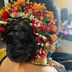 A beautiful and intricate floral hair bun, perfect for festivals or weddings. This style adds a touch of tradition and color to any look.