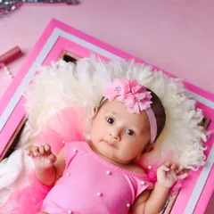 A close-up portrait from the Barbie-themed shoot, focusing on the baby's sweet face and the all-pink, glamorous setup.