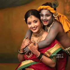 The pure joy and affection between a mother and her little Krishna. This close-up portrait focuses on their happy expressions and the intricate details of their costumes and jewelry, creating a memory that feels both divine and deeply personal.