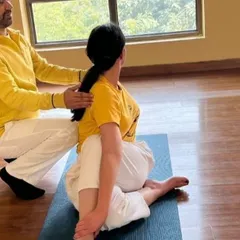 Providing hands-on assistance in an Asana Correction workshop. I help students refine their postures, like this spinal twist, to ensure proper alignment and deepen the benefits of the pose.
