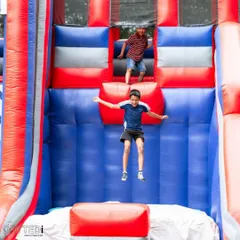 Kids having a blast on a large inflatable slide. I can arrange for a variety of bouncy castles and inflatables to bring high-energy fun to any birthday party.