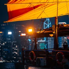 A close-up of the vibrant red sail of a junk boat against the glittering city lights. I focused on the details and textures to capture the feeling of being on the water at night.