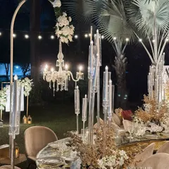 Another view of the glamorous mirrored table, showing the arched floral stands with hanging chandeliers. This adds height and drama to the overall reception decor.