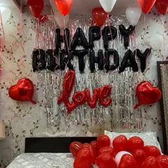 This is a popular birthday decoration theme using a black, red, and white color palette. I set up a silver fringe curtain as a backdrop for the 'Happy Birthday' foil balloons, with additional 'Love' and heart-shaped balloons to complete the romantic birthday surprise.
