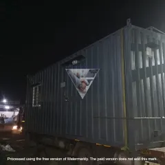 This photo shows a finished container office at my manufacturing yard at night, ready for dispatch. The corrugated steel exterior is extremely durable, and you can see the window and my company logo proudly displayed.