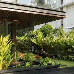 We designed quiet, contemplative spaces where the residents can connect with nature. This seating nook is nestled amidst lush greenery, sheltered by the overhead balcony, creating a perfect fusion of architecture and landscape.