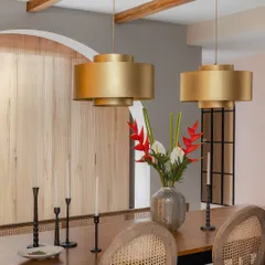 A close-up of the dining area in the Quiet Ornate home. The oversized brass pendant lights make a bold statement above the warm wood table, while cane chairs add a touch of natural texture.