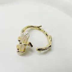 This minimal ring features a raw pearl set on a branch-like gold-plated band, inspired by nature.