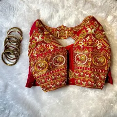 This image shows the sleeve detail of our red bird-themed blouse. You can see the texture and dimension created by combining Zardozi, threadwork, and beadwork to form the peacock and floral patterns.