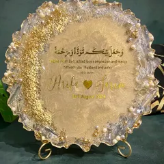 A beautiful resin engagement plaque designed to celebrate a new union. This piece features the couple's names, their special date, and a Quranic verse, all set in a shimmering gold and pearl design with a geode-style edge.