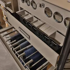 This detail shot showcases our smart storage solutions for trousers and accessories. The pull-out trouser rack keeps pants crease-free, while the sectioned drawer above provides organized storage for watches, belts, and other small items.