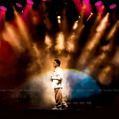 Capturing the full stage atmosphere during a live performance. This wide shot shows the artist on stage under dramatic spotlights, giving a sense of the scale and energy of the concert.
