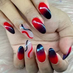 Make a bold statement with this dramatic red-to-black ombré design. The smooth gradient on almond-shaped nails is paired with abstract red and black swirls on a sheer accent nail, creating a look that is both fierce and artistic.