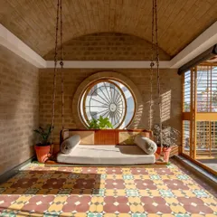 The semi-open family lounge is one of my favorite spaces in the house. The vaulted brick ceiling, patterned floor, and large circular pivot window create a perfect spot for relaxation, filled with light and air.
