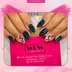 A dark and edgy design featuring a deep teal polish with a delicate snake illustration on a neutral accent nail. It's a subtle way to show off your bold side.