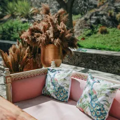 It's the little details that make a day unforgettable. For this event, we used custom-printed peacock cushions on a pink velvet sofa, set next to a large brass vase fatores pampas grass.
