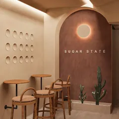 This seating nook at Sugar State Bakery embodies my love for minimalist, Wabi-Sabi design. The curved, textured walls and simple, elegant furniture create a pocket of calm for customers to enjoy their treats.