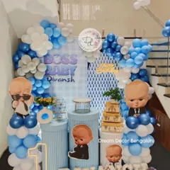 Here's a Boss Baby theme we set up in a cozy corner of a home. We used the staircase to create a multi-level balloon arch in shades of blue and white, perfectly framing the character cutouts and personalized name sign.